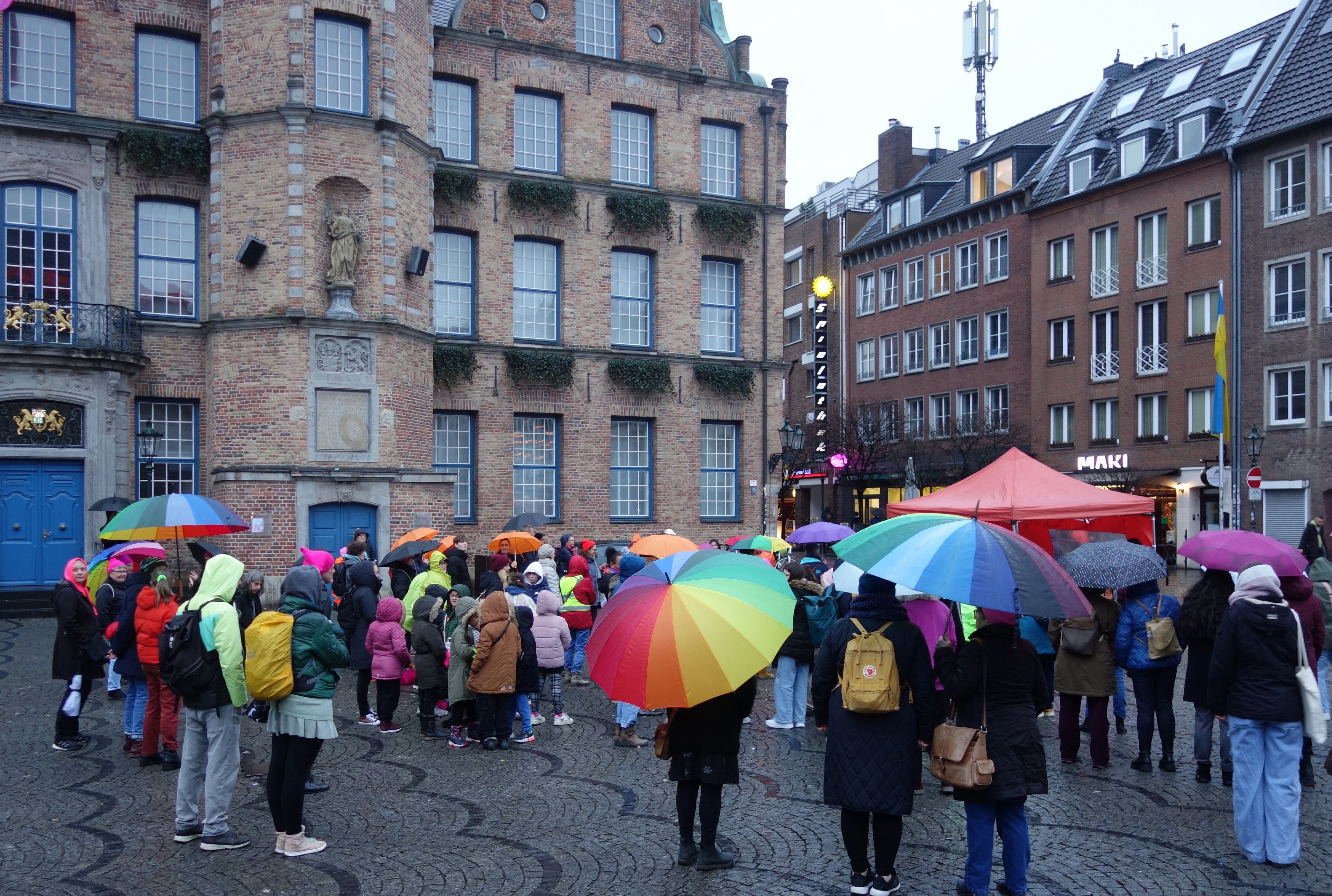 Uczestnicy i uczestniczki manifestacji One Billion Rising przeciw przemocy wobec kobiet na placu przed ratuszem w Düsseldorfie, luty 2024